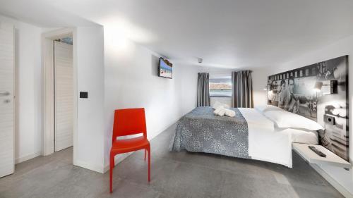 a bedroom with a bed and a red chair at Mini Suite con 1 Camera da letto (4 adulti) in Riccione
