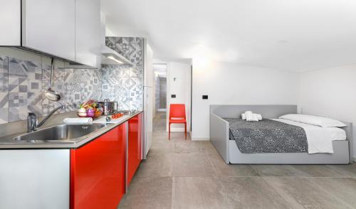 - une cuisine avec évier et un lit dans une chambre dans l'établissement Mini Suite con 1 Camera da letto (4 adulti), à Riccione