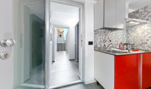 - une cuisine avec une armoire rouge et un évier dans l'établissement Mini Suite con 1 Camera da letto (4 adulti), à Riccione