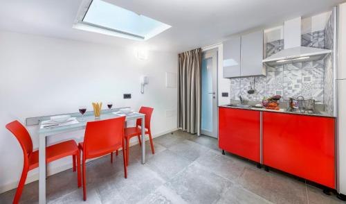 - une cuisine avec une table et des chaises rouges dans la chambre dans l'établissement Mini Suite con 1 Camera da letto (4 adulti), à Riccione