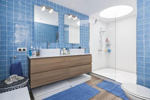 a blue tiled bathroom with a sink and a tub at Ocean's Eleven, Golf del Sur in San Miguel de Abona