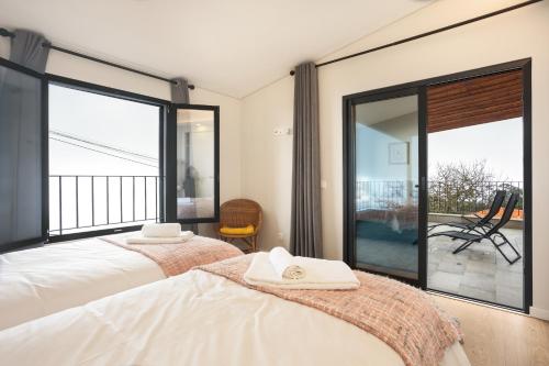 1 dormitorio con 2 camas y puertas correderas de cristal en Referta Apartamento T1, en Prazeres