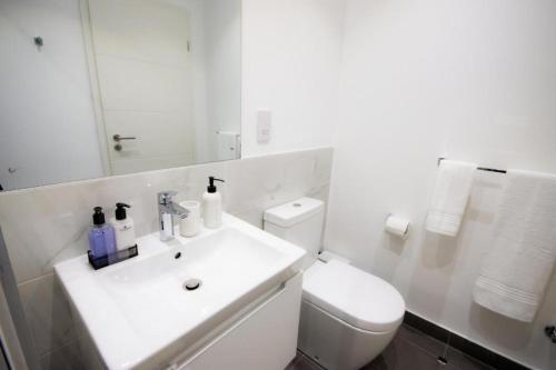 uma casa de banho branca com um lavatório e um WC em Splendid Apartments @ The Lennox em Acra