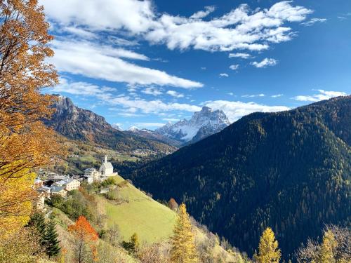 a castle on a hill with a mountain in the background at Tabia Suite Pelmo in Villagrande