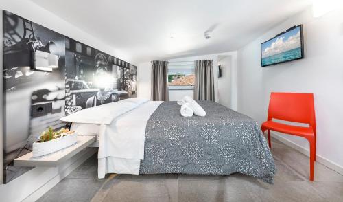 una camera da letto con un letto e una sedia rossa di Mini Suite (3 adulti) a Riccione