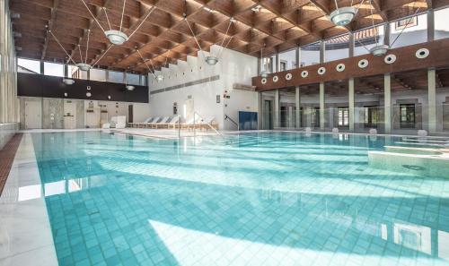 - une grande piscine avec des carreaux bleus dans un bâtiment dans l'établissement Gran Hotel Las Caldas by blau hotels, à Las Caldas