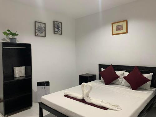 sypialnia z łóżkiem z białą pościelą i czerwonymi poduszkami w obiekcie Fil's Resort w mieście Moalboal