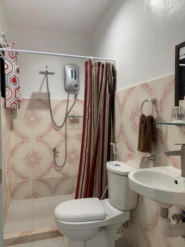 a bathroom with a toilet and a sink and a shower at Fil's Resort in Moalboal