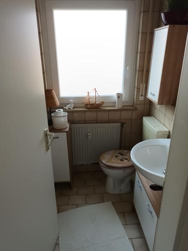 La salle de bains est pourvue de toilettes, d'un lavabo et d'une fenêtre. dans l'établissement Wie Daheim, à Nuremberg