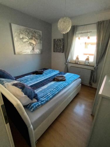- une chambre avec un lit doté de draps bleus et une fenêtre dans l'établissement Wie Daheim, à Nuremberg