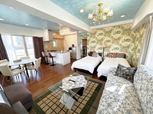 Sala de estar con 2 camas y mesa en Ocean Villa Tin Gala, en Onna
