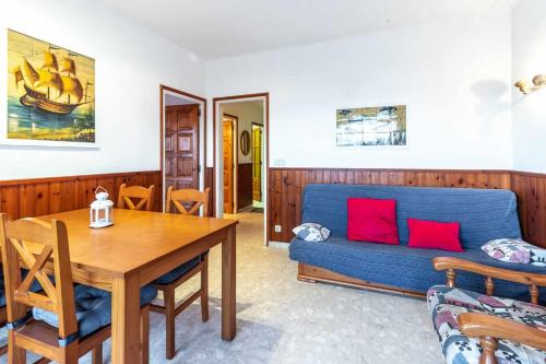 a living room with a blue couch and a table at Isard 4 bis Apartamento junto a la playa in Franciach