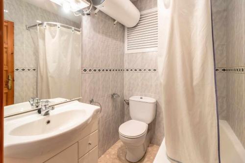 a bathroom with a toilet and a sink and a shower at Isard 4 bis Apartamento junto a la playa in Franciach