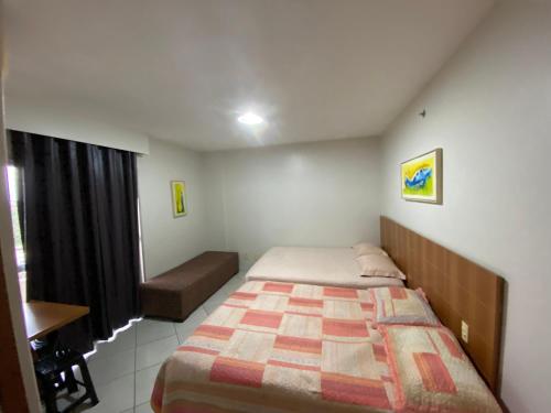 a bedroom with a bed and a desk and a window at Locação Caldas Novas 1105 in Caldas Novas