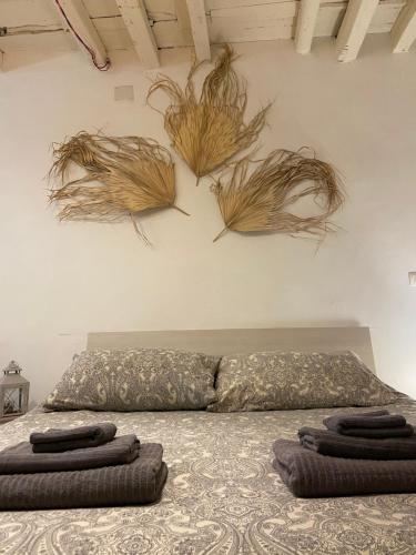 a bedroom with a bed with some plants on the wall at B&B Le Statuine in Barletta