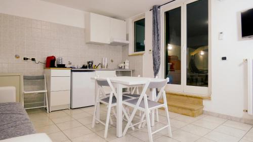 een witte keuken met een tafel en stoelen. bij Relux in Bari