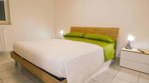 sypialnia z białym łóżkiem z zielonymi poduszkami w obiekcie Relux w mieście Bari