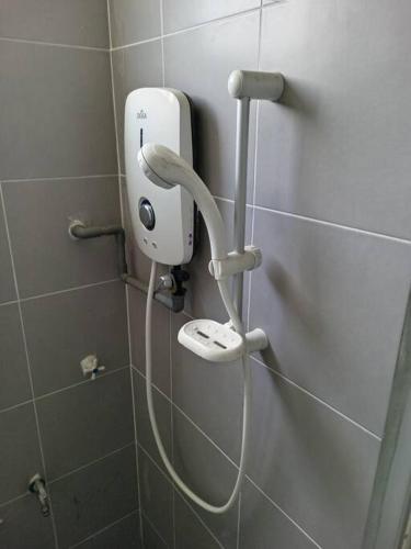 a white hairdryer on a wall in a bathroom at Studio House Kampar in Kampar