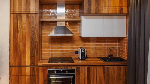 a small kitchen with a sink and a stove at Aparthotel Poljice in Jahorina