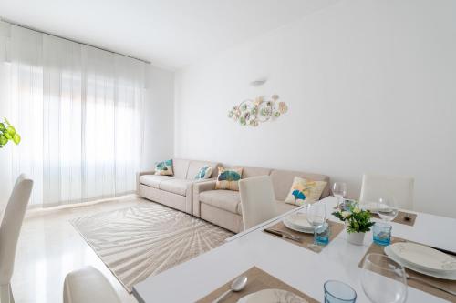 Sala de estar blanca con sofá y mesa en San Siro Big House Wifi Netflix Free Parking, en Milán