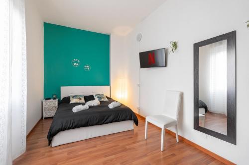 1 dormitorio con 1 cama con pared verde en San Siro Big House Wifi Netflix Free Parking, en Milán