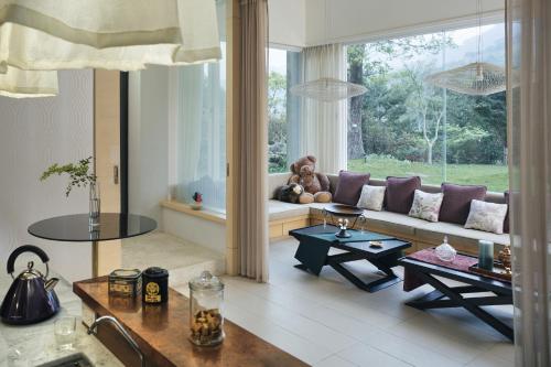 a living room with a couch and a teddy bear at Around The Tree Manor in Shitan
