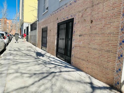 a brick building with a door on the side of a sidewalk at HOSPEDAJE NUEVA NUMANCIA in Madrid