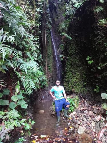 a man standing in a stream in a forest at Finca Sueno de Osa in Puerto Jiménez