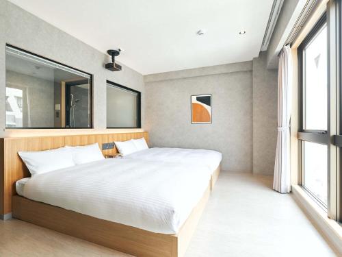 那霸的住宿－Rakuten STAY naha-tomarifuto 7F Twin Room，一间卧室设有一张大床和一个窗户。