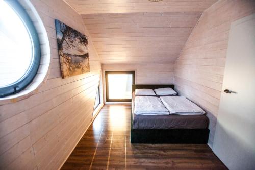 mały pokój z 2 łóżkami w drewnianej ścianie w obiekcie Royal Palm Mielno w mieście Mielno