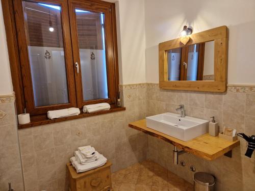 bagno con lavandino e specchio di Azienda Agricola Agriturismo I Sei Petali a Capo di Ponte