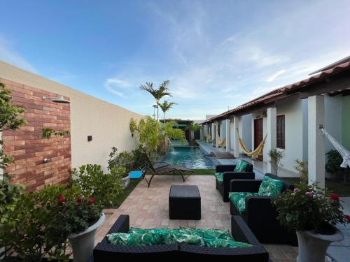 拉巴拉德納聖米格爾的住宿－Casa de Temporada - Barra de São Miguel，带沙发的庭院和大楼内的游泳池