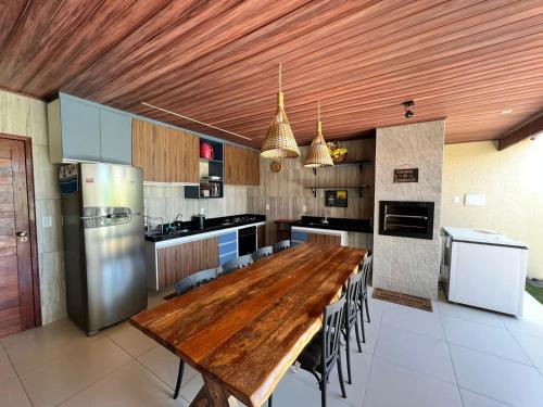 een grote keuken met een houten tafel en apparatuur bij Casa de Temporada - Barra de São Miguel in Barra de São Miguel