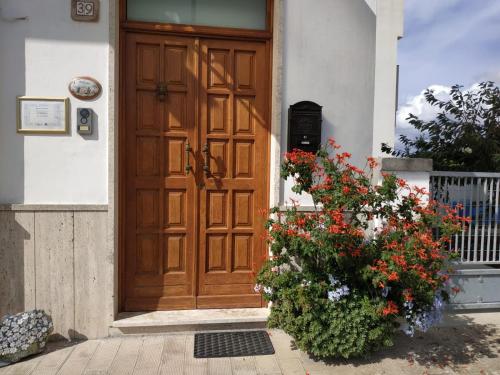 una porta di legno di una casa con un mazzo di fiori di Welcome to Alberobello ad Alberobello