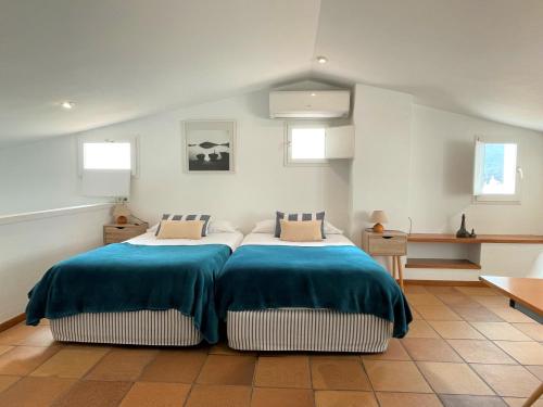 una camera con due letti con lenzuola blu e bianche di MATILLA - Apartamento con parquin a Cadaqués
