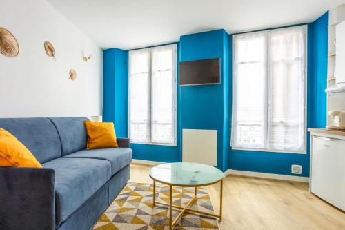 un soggiorno con pareti blu e un divano blu di Superb studio just nearby the Versailles palace - Welkeys a Versailles