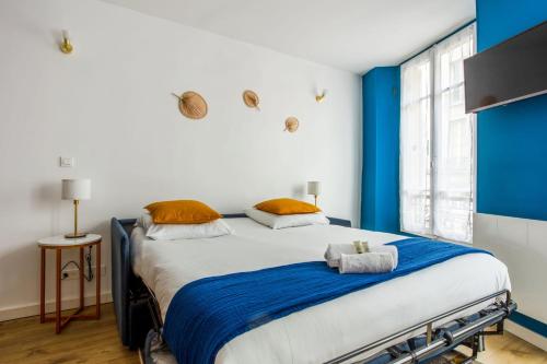 - une chambre bleue et blanche avec un grand lit dans l'établissement Studio Petrolio - Welkeys, à Versailles