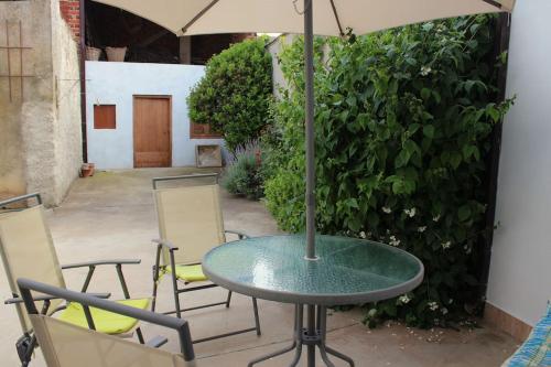 a table and chairs with an umbrella on a patio at Casa Rural Tío Samuel in Fresno de la Vega