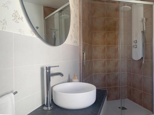a bathroom with a sink and a shower with a mirror at Casa Rural Tío Samuel in Fresno de la Vega