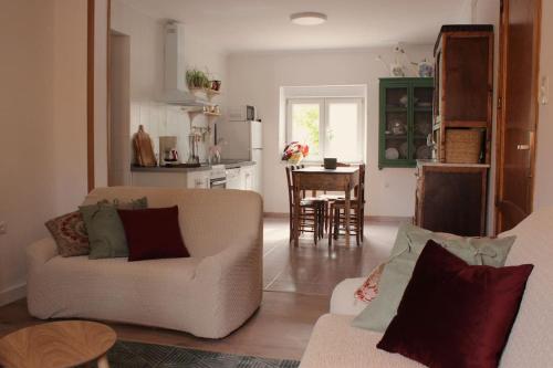 a living room with two couches and a kitchen at Casa Rural Tío Samuel in Fresno de la Vega