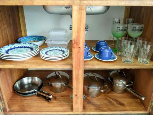 a wooden shelf with plates and bowls and dishes at Villa Bangalu in Porto De Galinhas