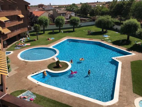 an overhead view of a swimming pool with people in it at BaruHaus urbanizacion con piscina Villamañan 