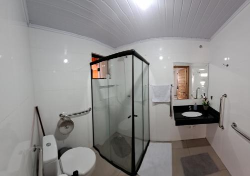 a bathroom with a shower and a toilet and a sink at Hospedaria Maviane Executive in Treze Tílias