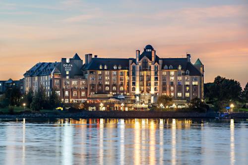 a large building next to the water at night at Delta Hotels by Marriott Victoria Ocean Pointe Resort in Victoria