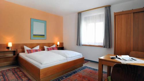 a bedroom with a large bed and a desk and a desk at Hotel Restaurant Onkel-Otto in Pommern