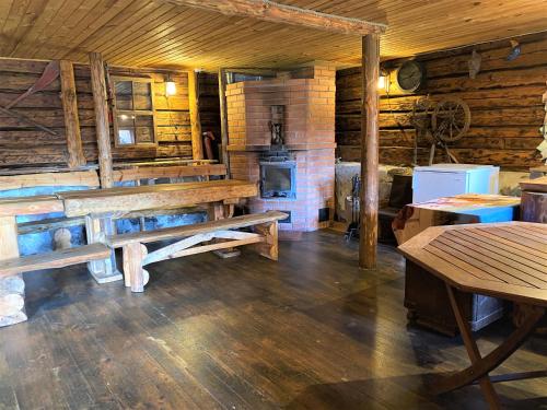 Habitación con bancos de madera y estufa en una cabaña. en Kõrtsimaja, en Myza Kastre