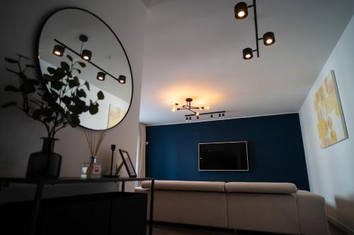 uma sala de estar com um sofá e uma parede azul em Chill vibes apartment em Brasov
