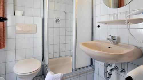 a bathroom with a sink and a toilet and a shower at Hotel Restaurant Onkel-Otto in Pommern