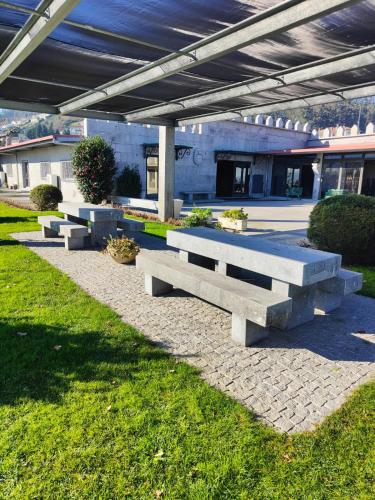 a row of concrete benches sitting under a building at Quinta de Basto House in Felgueiras