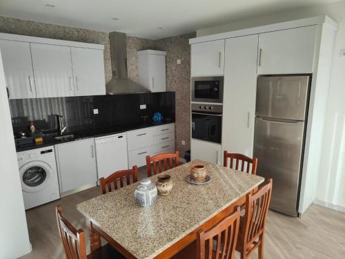 a kitchen with a table with chairs and a refrigerator at Quinta de Basto House in Felgueiras